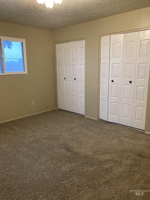 unfurnished bedroom featuring carpet, a closet, baseboards, and a textured ceiling