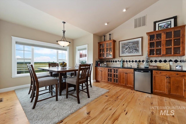 dining space with recessed lighting, visible vents, baseboards, light wood finished floors, and indoor wet bar