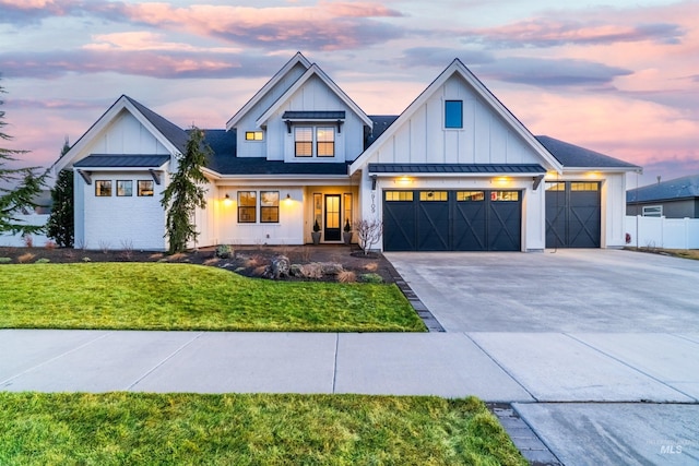 modern farmhouse style home featuring a standing seam roof, a front lawn, board and batten siding, and driveway