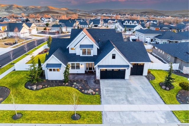 view of front of home with a front yard, fence, a residential view, decorative driveway, and board and batten siding