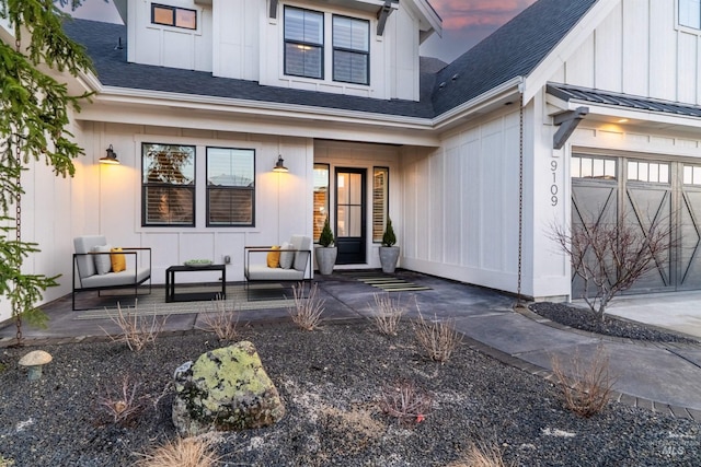 entrance to property featuring a standing seam roof, covered porch, a garage, board and batten siding, and metal roof