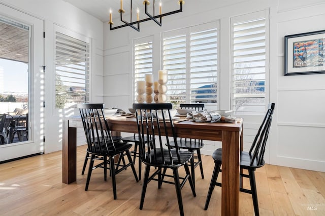 dining space with light wood-style flooring and a notable chandelier