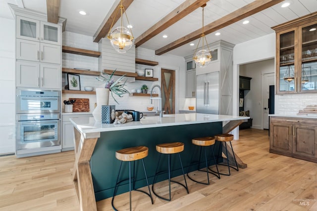 kitchen featuring open shelves, light countertops, tasteful backsplash, and stainless steel appliances