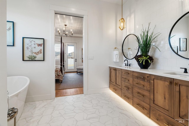 ensuite bathroom featuring a sink, a freestanding tub, ensuite bath, and double vanity