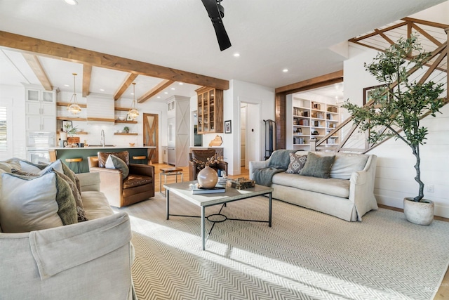 living room with recessed lighting, beamed ceiling, and stairs