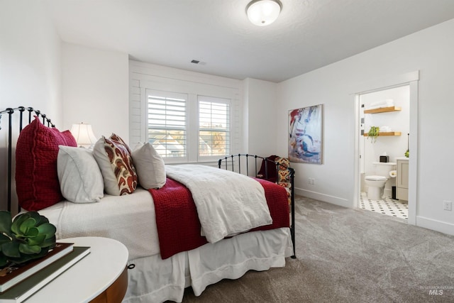 bedroom with connected bathroom, carpet, visible vents, and baseboards