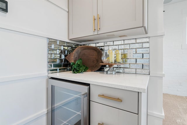 interior space featuring decorative backsplash, beverage cooler, and brick wall