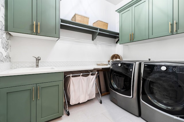 clothes washing area with washing machine and clothes dryer, cabinet space, light tile patterned flooring, and a sink