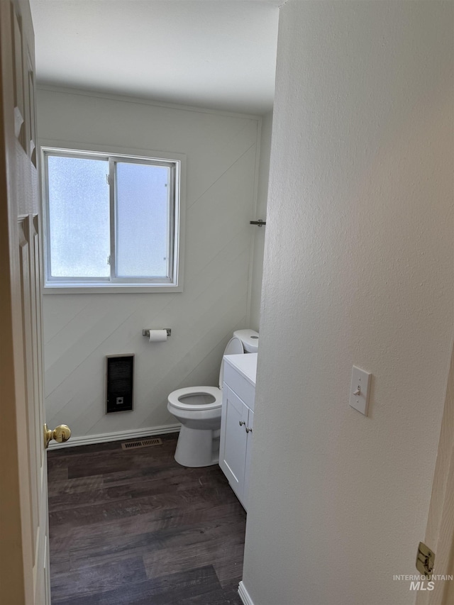 bathroom with visible vents, wood finished floors, toilet, and vanity