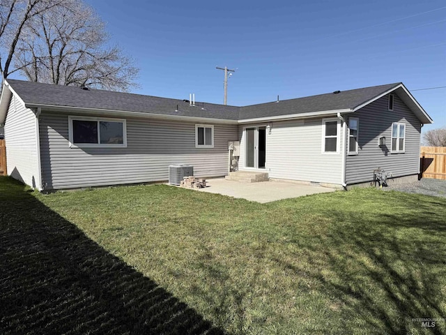 rear view of house with fence, entry steps, a patio, central AC unit, and a yard