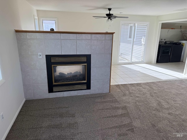 details with carpet flooring, visible vents, a ceiling fan, a tile fireplace, and washing machine and dryer