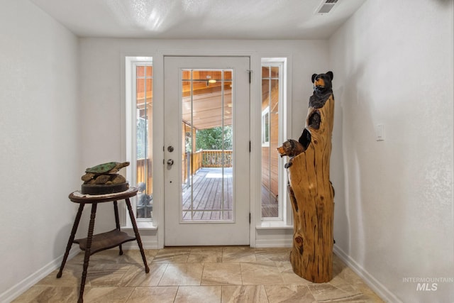 doorway with visible vents and baseboards