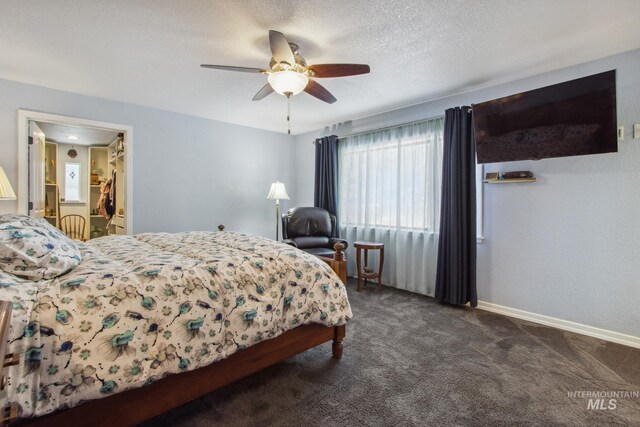 bedroom featuring ceiling fan, baseboards, dark colored carpet, and a textured ceiling