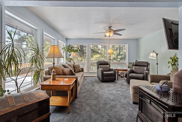 living room featuring carpet floors, ceiling fan, and a textured ceiling