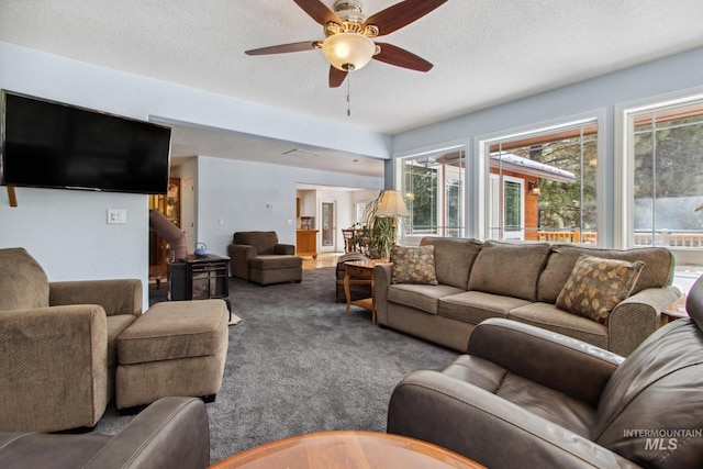 living area featuring carpet, ceiling fan, and a textured ceiling