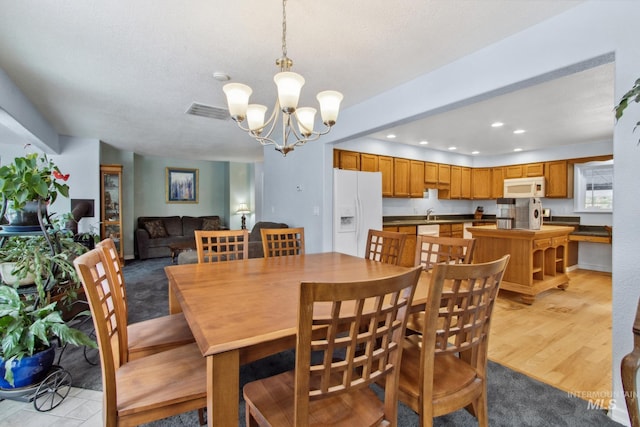 dining area featuring recessed lighting, visible vents, light wood finished floors, and an inviting chandelier