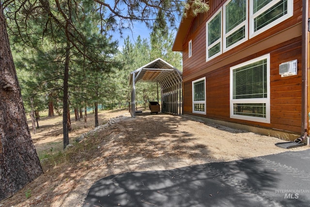 view of yard featuring a carport and a wall unit AC