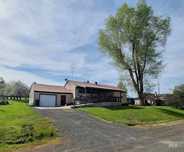 view of front of house featuring a garage, a front yard, and a porch