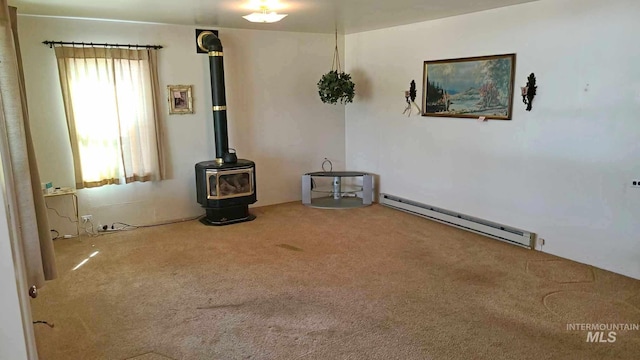 carpeted empty room with a baseboard radiator and a wood stove