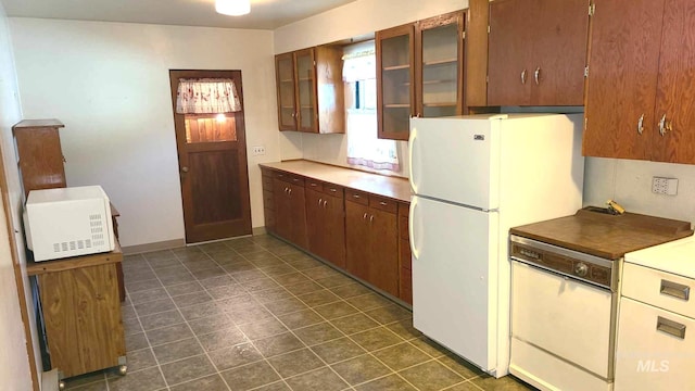 1120 N State St, Grangeville, ID 83530 - kitchen featuring white appliances, glass insert cabinets, and dark tile patterned flooring
