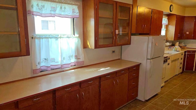 kitchen with a healthy amount of sunlight, white fridge, and dark tile patterned flooring