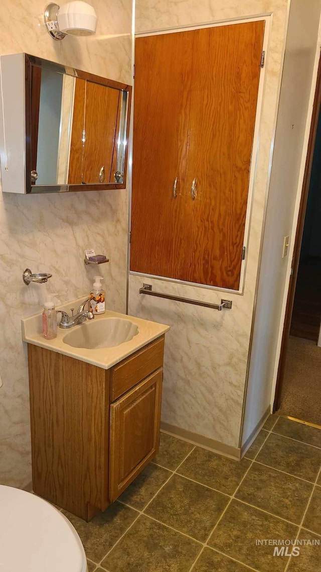 bathroom featuring tile patterned flooring, vanity, and toilet