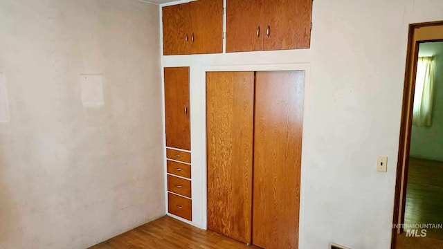 unfurnished bedroom with a closet and light wood-type flooring