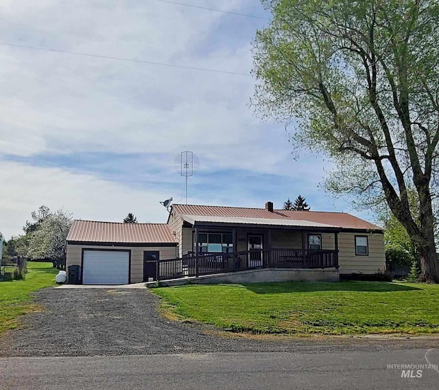 view of front of property featuring a garage, a front lawn, and covered porch