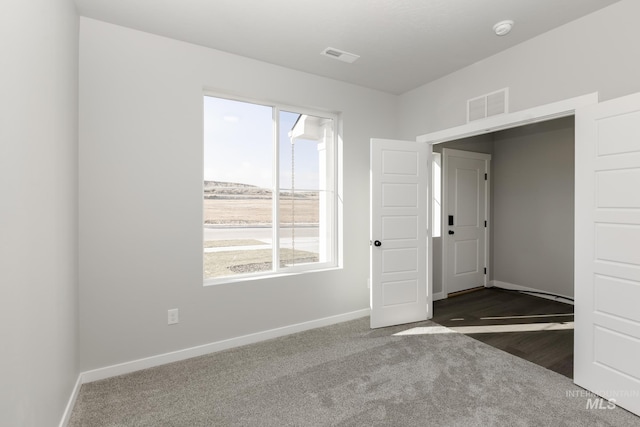 carpeted empty room with baseboards and visible vents