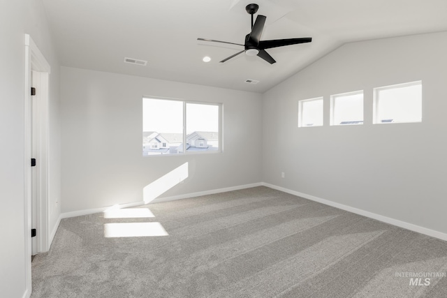 carpeted spare room with a ceiling fan, baseboards, visible vents, and vaulted ceiling