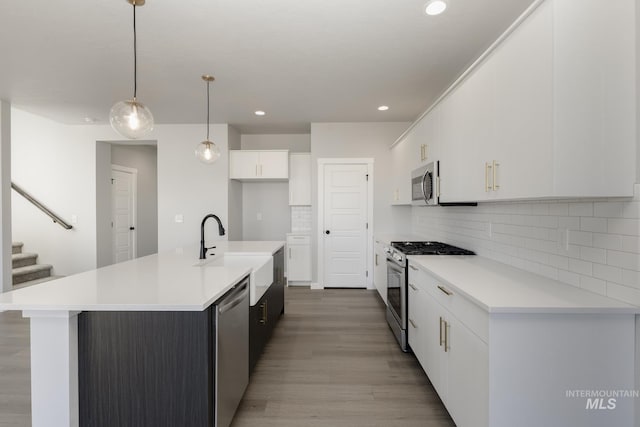 kitchen featuring stainless steel appliances, tasteful backsplash, light countertops, white cabinets, and light wood-style floors