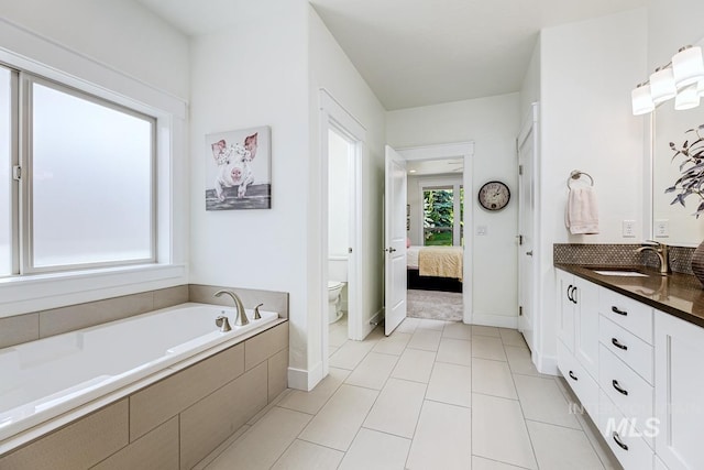 1833 N Monterossa, Eagle, ID 83616 - ensuite bathroom with toilet, a garden tub, vanity, and baseboards