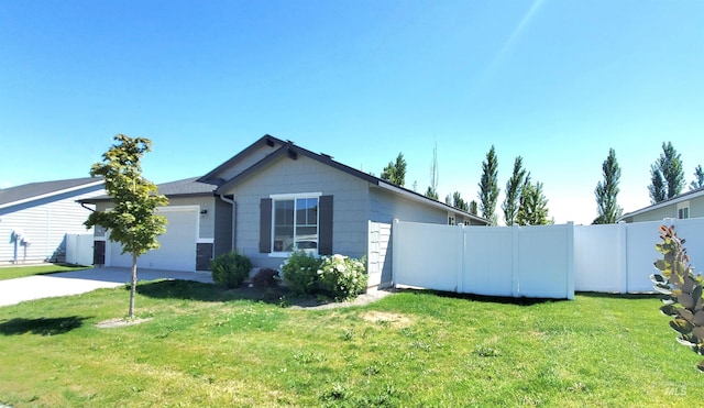 view of property exterior featuring concrete driveway, an attached garage, fence, and a yard