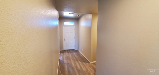 hallway with hardwood / wood-style flooring