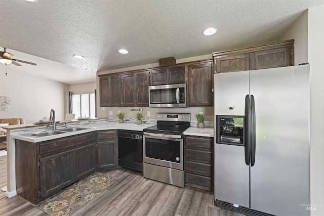 2908 E Iowa Ave, Nampa, ID 83686 - kitchen featuring stainless steel appliances, a sink, a peninsula, light countertops, and a textured ceiling