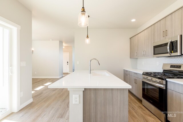 2804 N Eagle Meadow Ave, Kuna, ID 83634 - kitchen with tasteful backsplash, light countertops, appliances with stainless steel finishes, modern cabinets, and a sink