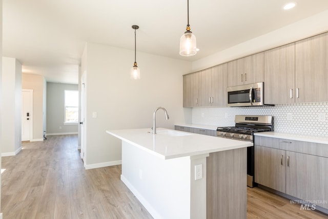 2804 N Eagle Meadow Ave, Kuna, ID 83634 - kitchen with a sink, light countertops, decorative backsplash, appliances with stainless steel finishes, and a kitchen island with sink