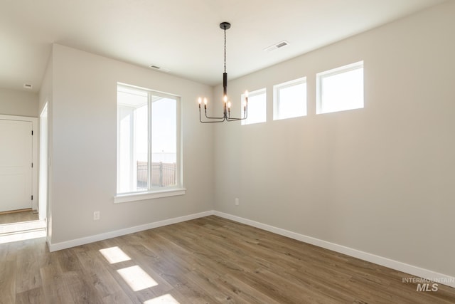 2804 N Eagle Meadow Ave, Kuna, ID 83634 - unfurnished dining area featuring visible vents, baseboards, an inviting chandelier, and wood finished floors