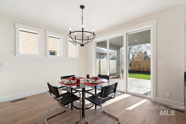 819 Cedar Point Way, Nampa, ID 83686 - dining area featuring a chandelier, wood finished floors, and baseboards