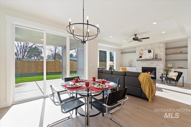 819 Cedar Point Way, Nampa, ID 83686 - dining space with a ceiling fan, a fireplace, wood finished floors, a chandelier, and a raised ceiling