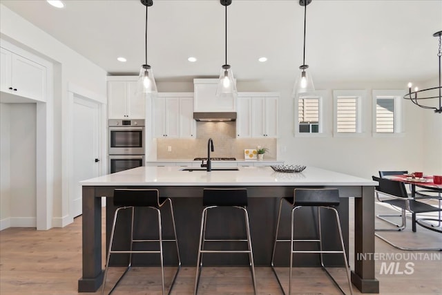 819 Cedar Point Way, Nampa, ID 83686 - kitchen featuring double oven, white cabinetry, tasteful backsplash, light wood finished floors, and light countertops