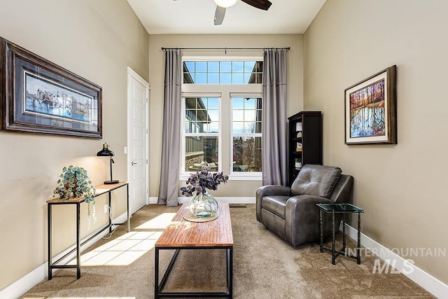 sitting room featuring baseboards, carpet floors, and a ceiling fan