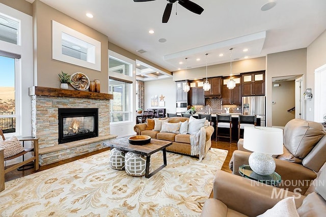 living room with light wood-style flooring, recessed lighting, a fireplace, and visible vents