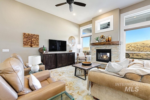 living area with a stone fireplace, recessed lighting, and ceiling fan