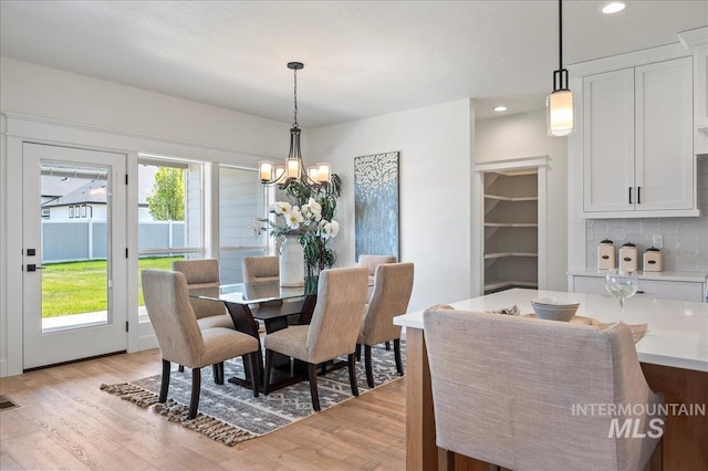 dining room featuring light hardwood / wood-style floors, an inviting chandelier, and a healthy amount of sunlight