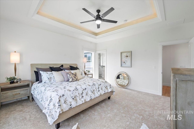 bedroom featuring ceiling fan, crown molding, light carpet, and a raised ceiling