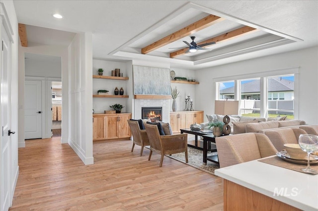 living room with light hardwood / wood-style floors, ceiling fan, and a fireplace