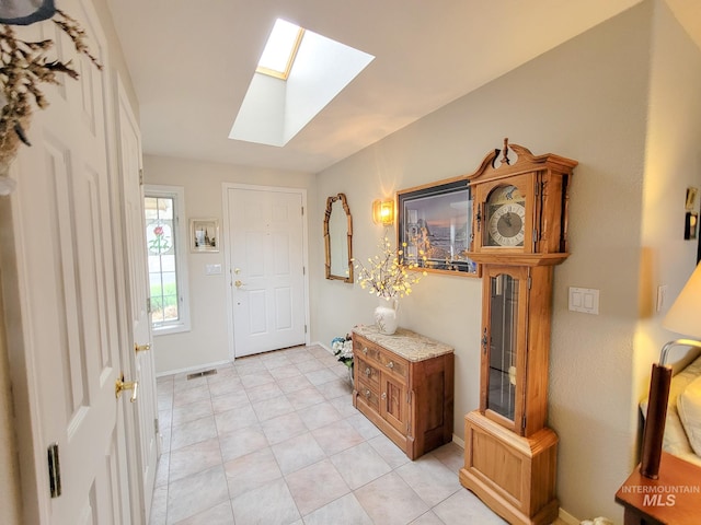 entrance foyer featuring light tile flooring and a skylight