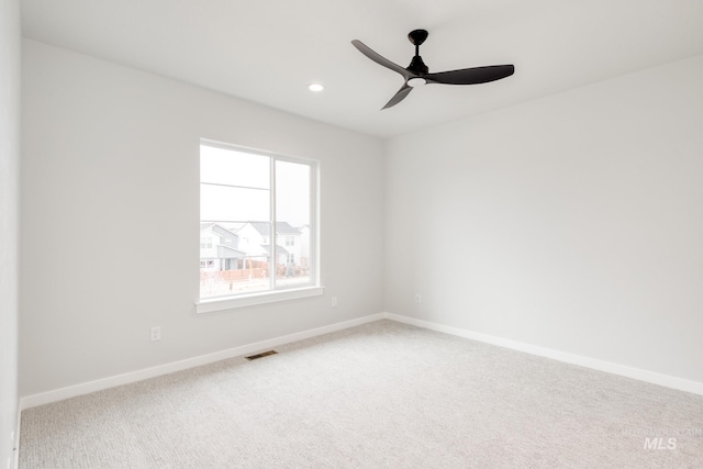 carpeted spare room featuring ceiling fan