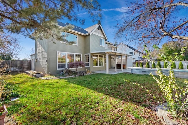 rear view of house featuring a patio and a lawn